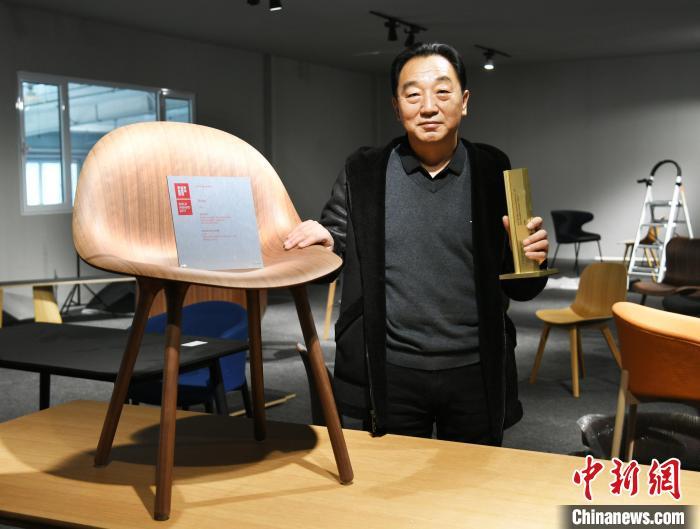 圖為產(chǎn)業(yè)園內(nèi)的一家公司負責人展示獲得德國IF設(shè)計金獎的椅子?！∷蚊魸?攝